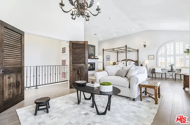 a living room with furniture chandelier and a wooden floor