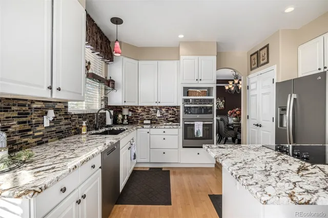 a kitchen with stainless steel appliances kitchen island granite countertop a refrigerator and a stove top oven