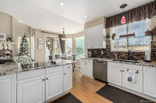 a kitchen with stainless steel appliances granite countertop a sink a stove and cabinets