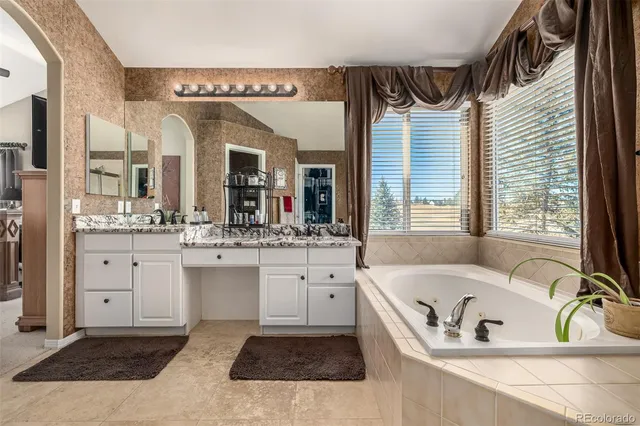 a bathroom with a tub sink and mirror