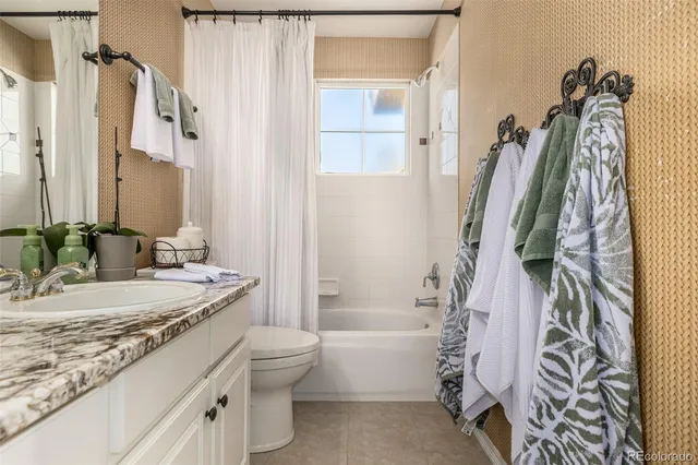 a bathroom with a granite countertop sink a toilet and a bathtub