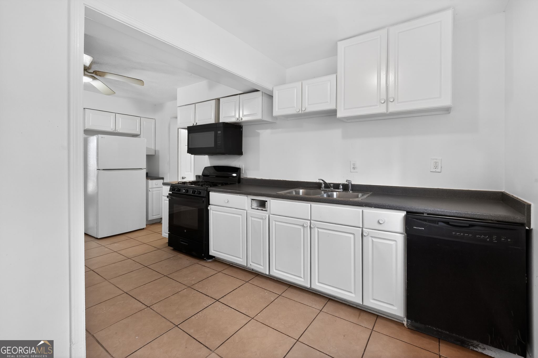 4629 ROUSAY Court Stone Mountain, GA 30083 - Photo 17 of 33 a kitchen with granite countertop white cabinets and stainless steel appliances