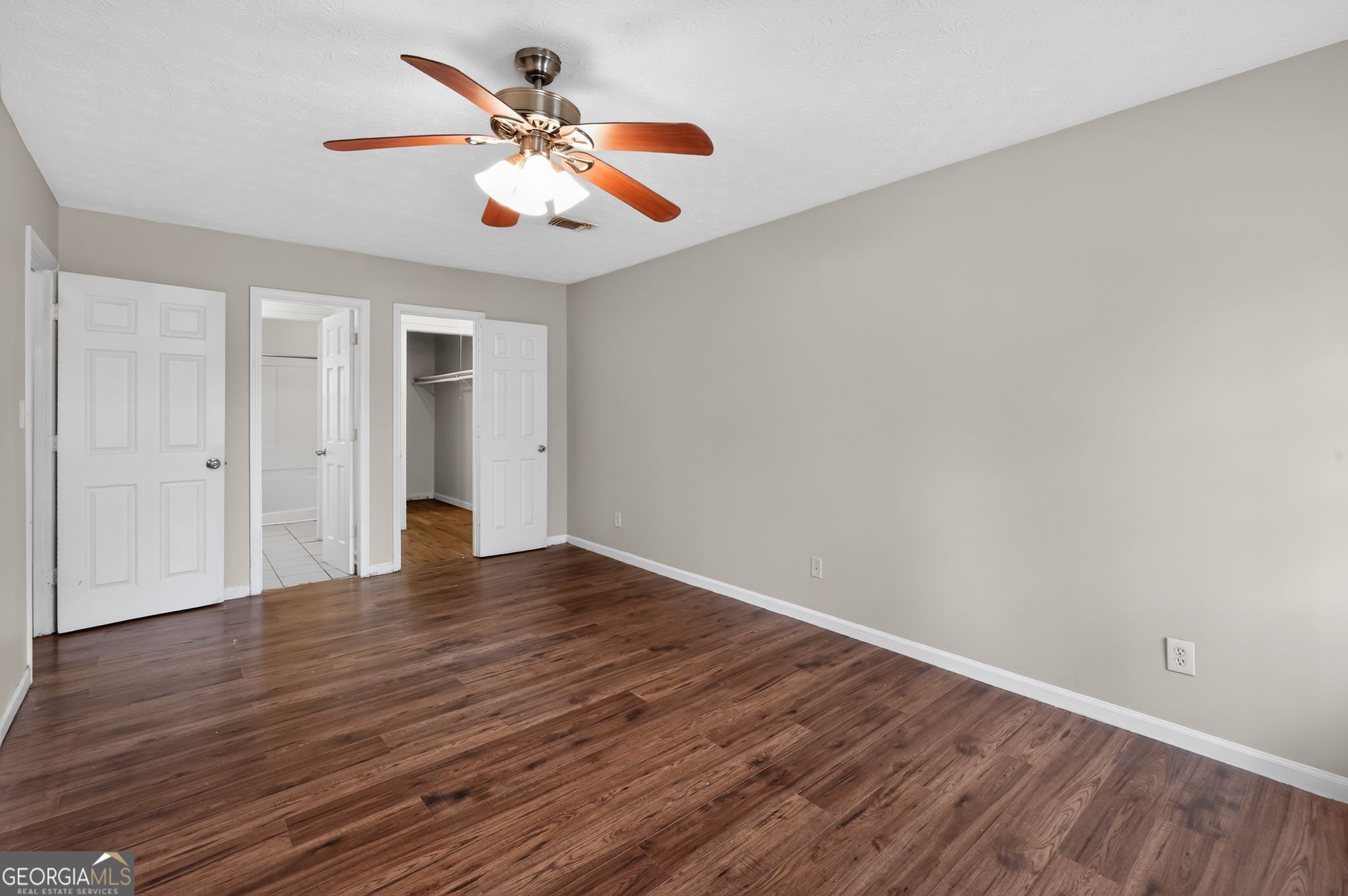 4629 ROUSAY Court Stone Mountain, GA 30083 - Photo 19 of 33 a view of an empty room with wooden floor and a ceiling fan
