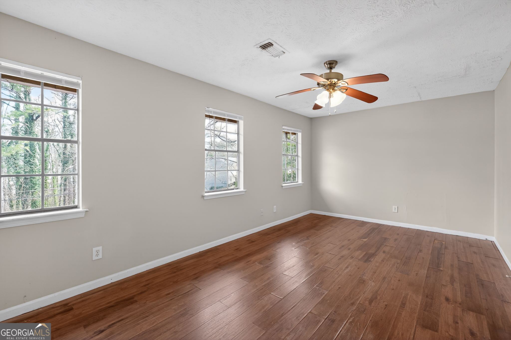 4629 ROUSAY Court Stone Mountain, GA 30083 - Photo 8 of 33 an empty room with wooden floor ceiling fan and window