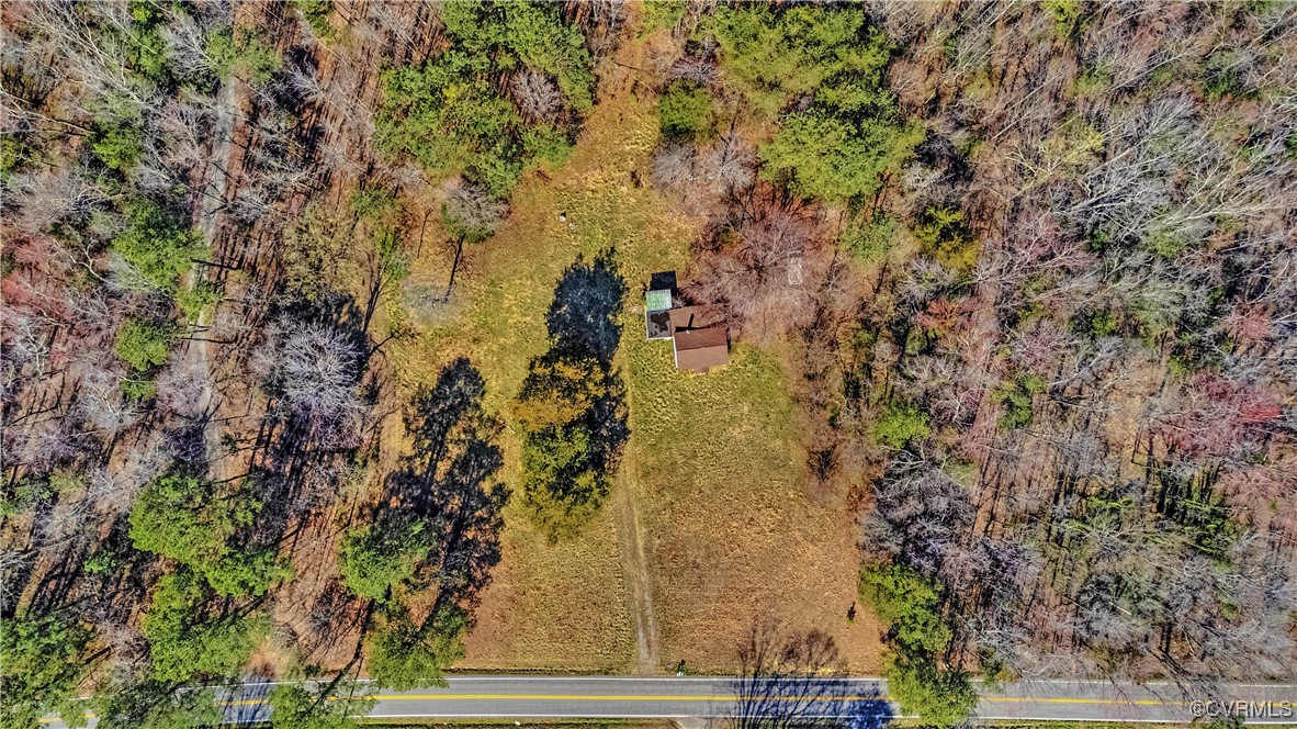 Birds eye view of property featuring a wooded view