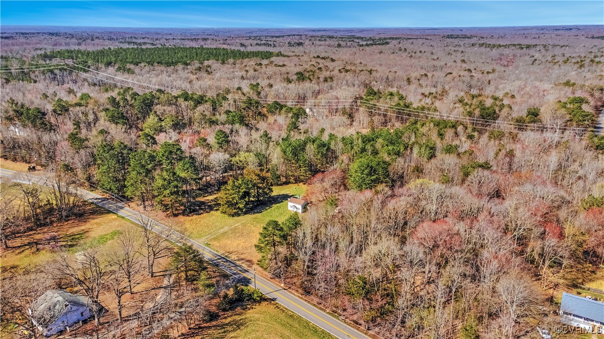 Birds eye view of property featuring a forest view
