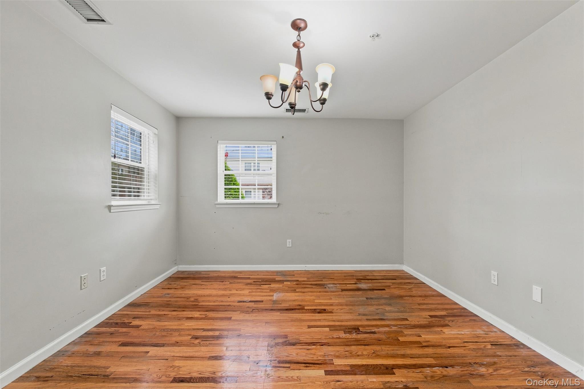 7 Elm Street, Unit 112 Spring Valley, NY 10977 - Photo 28 of 37 Spacious room featuring rich wood-finish flooring, light gray wall tones, and white trim