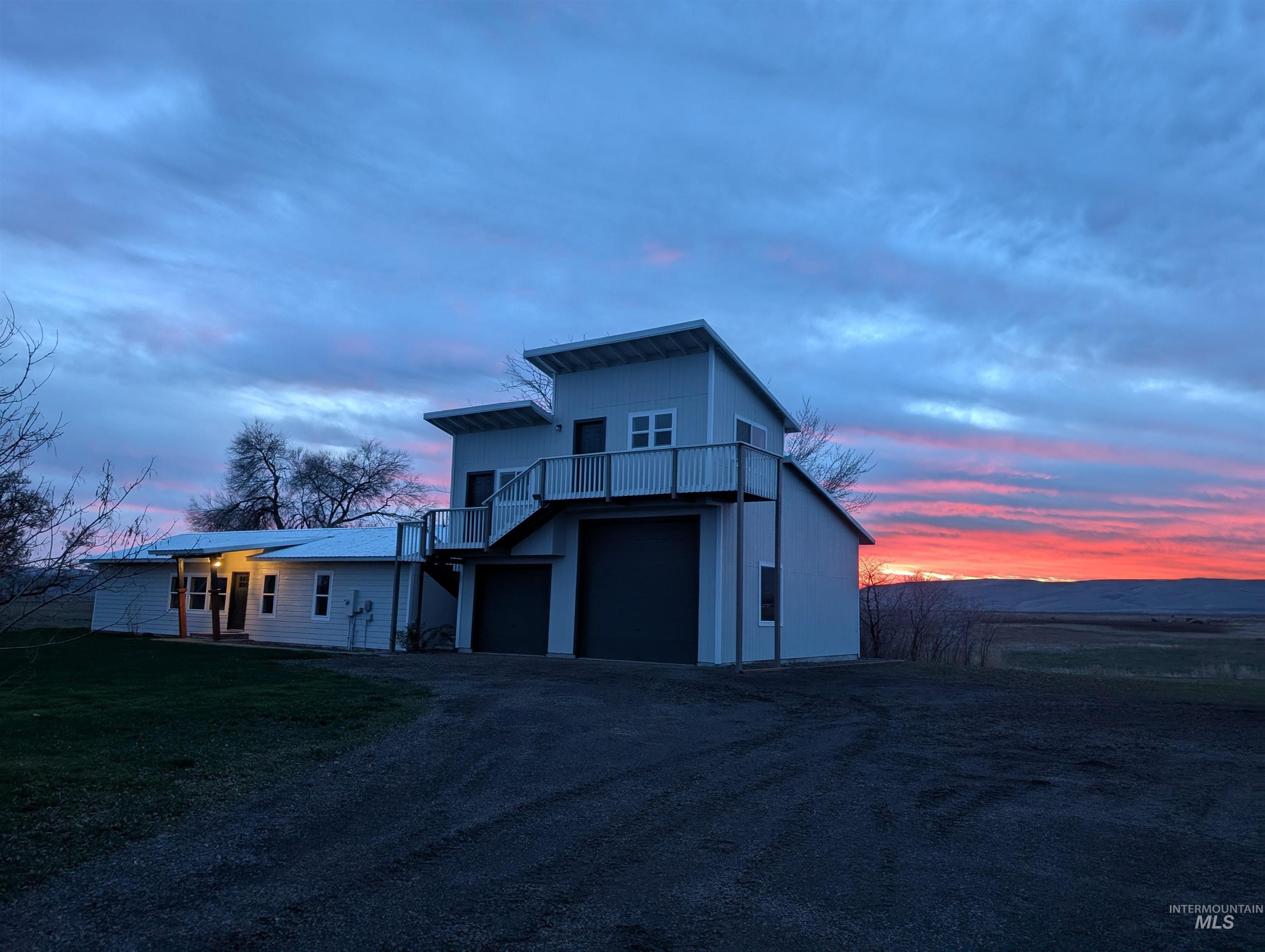 2253 Waite Road Midvale, ID 83645 - Photo 17 of 49 View of front of home featuring a balcony, dirt driveway, an attached garage, and a front yard