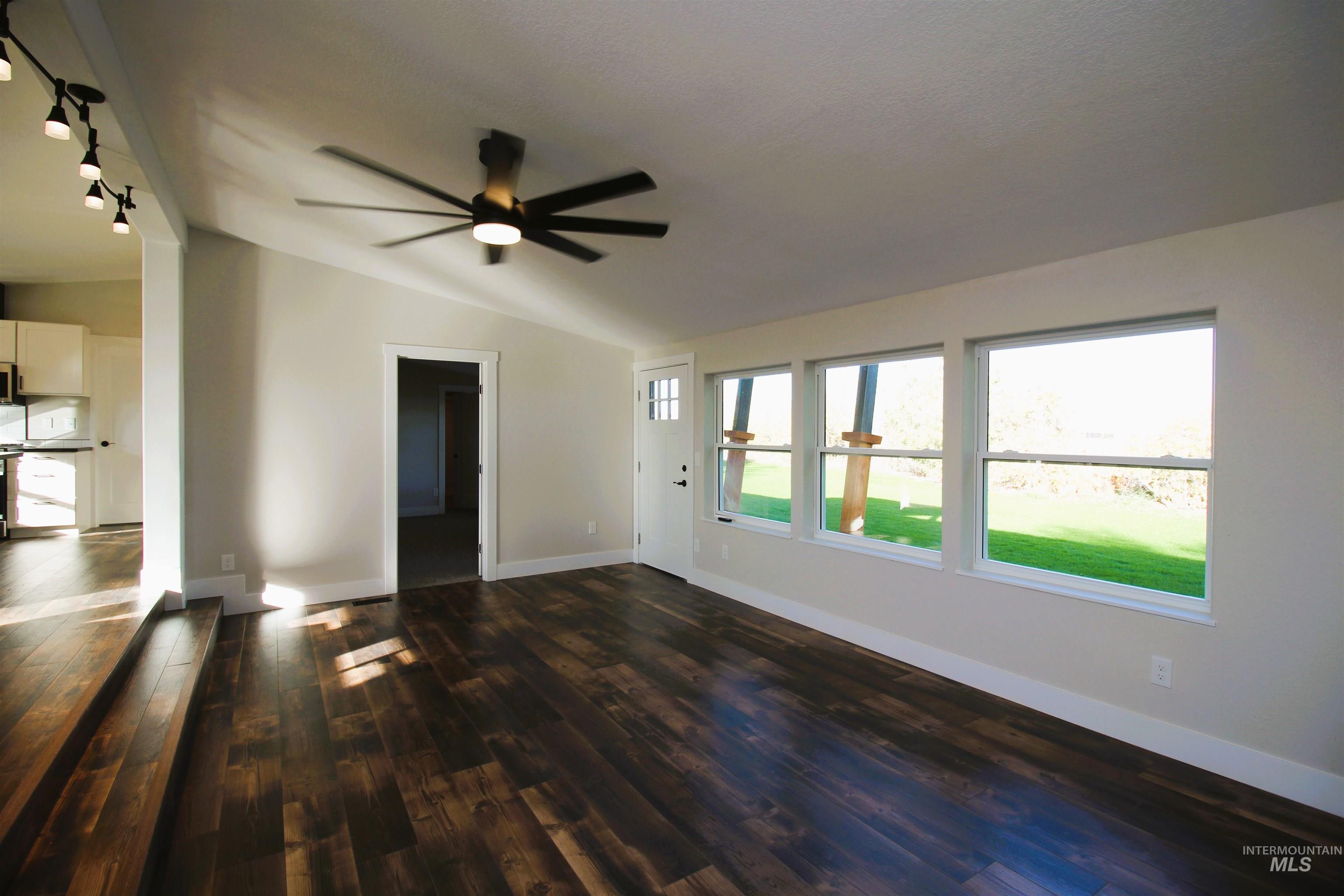 2253 Waite Road Midvale, ID 83645 - Photo 20 of 49 Unfurnished living room featuring vaulted ceiling, dark wood-type flooring, and a ceiling fan