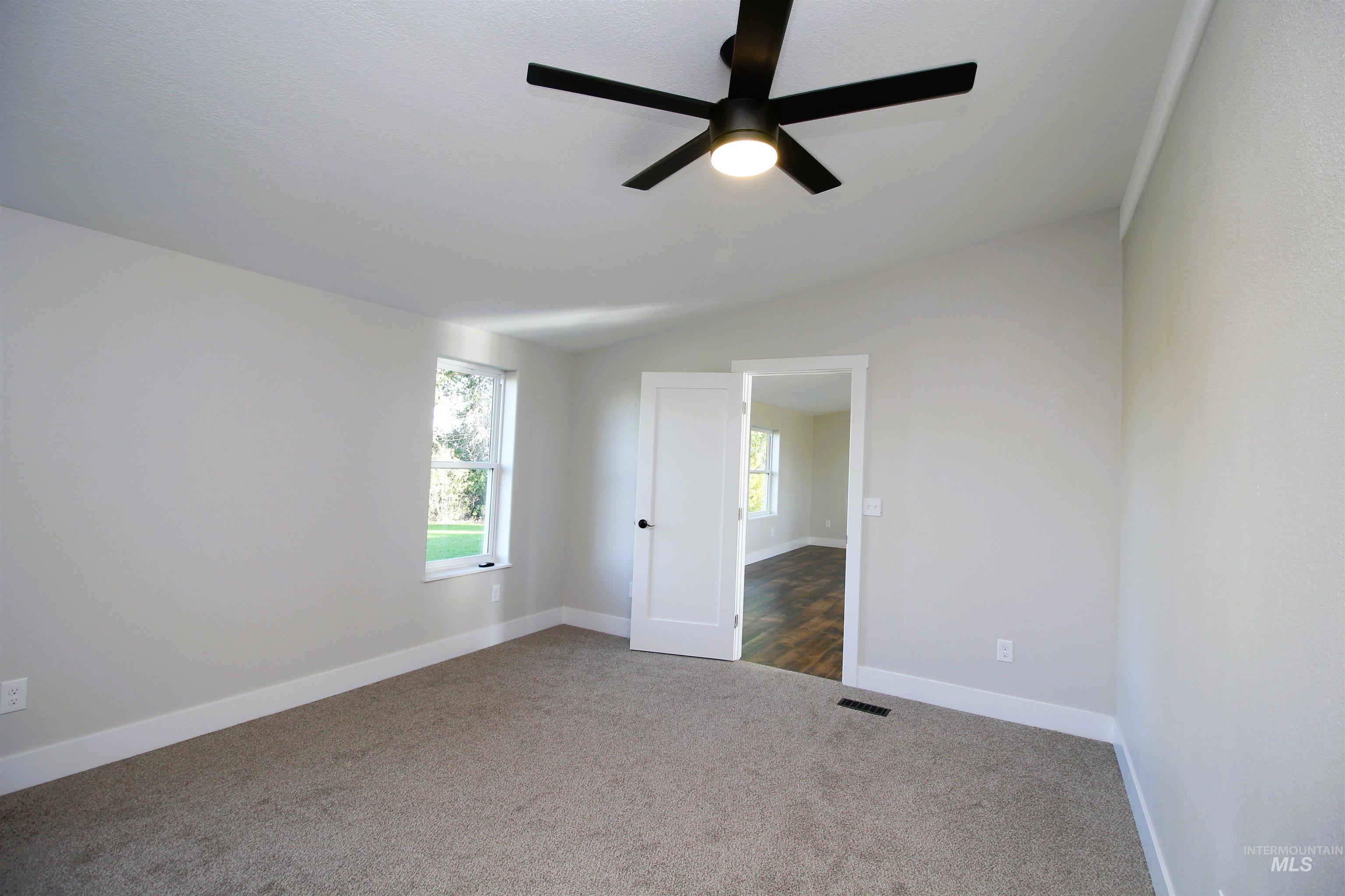 2253 Waite Road Midvale, ID 83645 - Photo 21 of 49 Unfurnished room with vaulted ceiling, dark colored carpet, and ceiling fan
