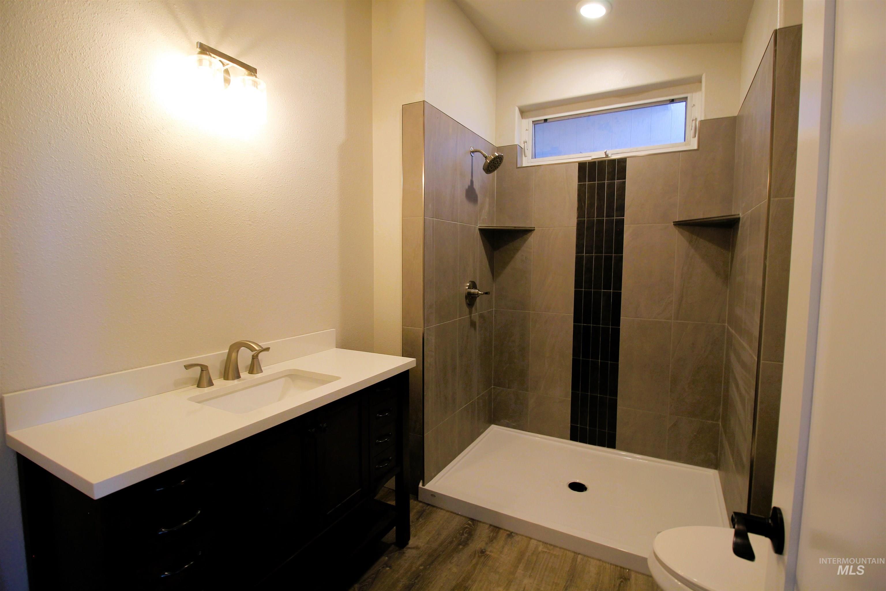 2253 Waite Road Midvale, ID 83645 - Photo 25 of 49 Full bathroom featuring vanity, dark wood finished floors, and tiled shower