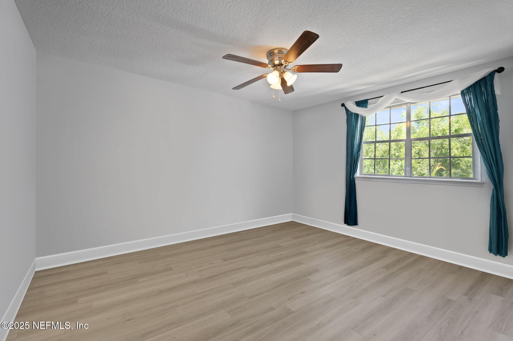 4915 Baymeadows Road, Unit 8H Jacksonville, FL 32217 - Photo 16 of 20 an empty room with wooden floor fan and windows