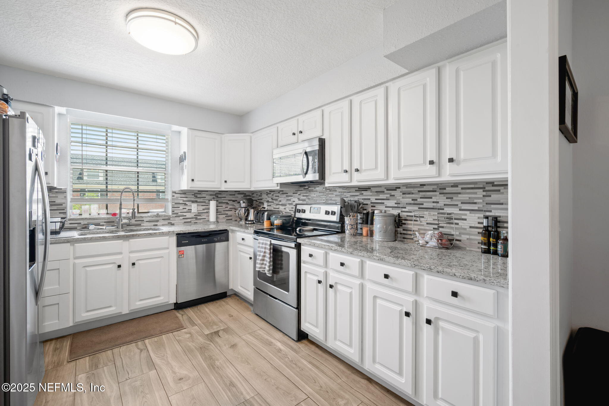 4915 Baymeadows Road, Unit 8H Jacksonville, FL 32217 - Photo 7 of 20 a kitchen with granite countertop white cabinets white stainless steel appliances with a sink and dishwasher