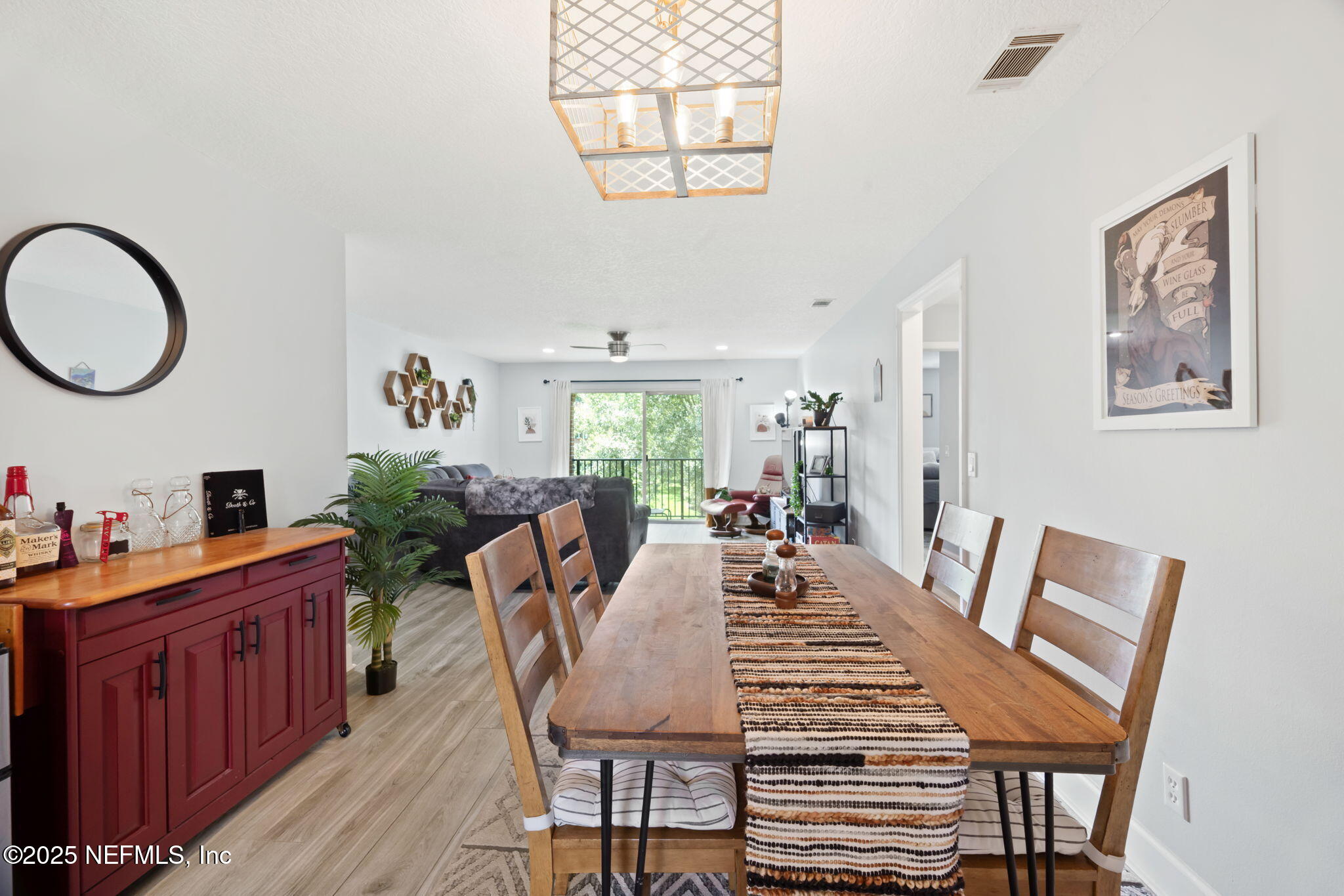 4915 Baymeadows Road, Unit 8H Jacksonville, FL 32217 - Photo 8 of 20 a view of a dining room with furniture a chandelier and wooden floor