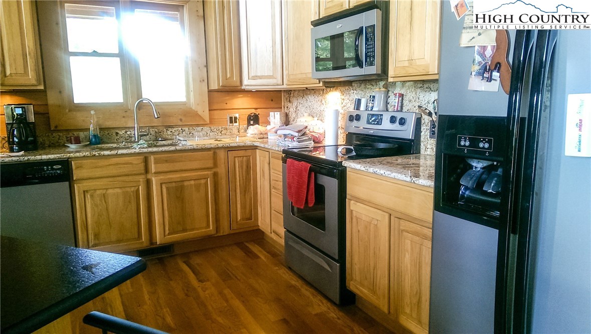 97 Turtle Ridge Road Sparta, NC 28675 - Photo 6 of 33 a kitchen with stainless steel appliances granite countertop a stove a sink and a refrigerator