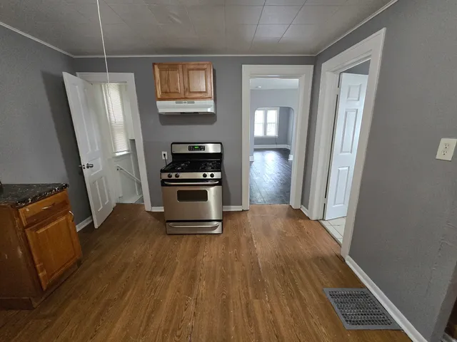 a kitchen with wooden floor and a refrigerator