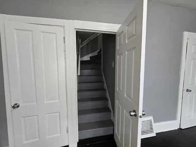 a view of a hallway with wooden floor and entryway