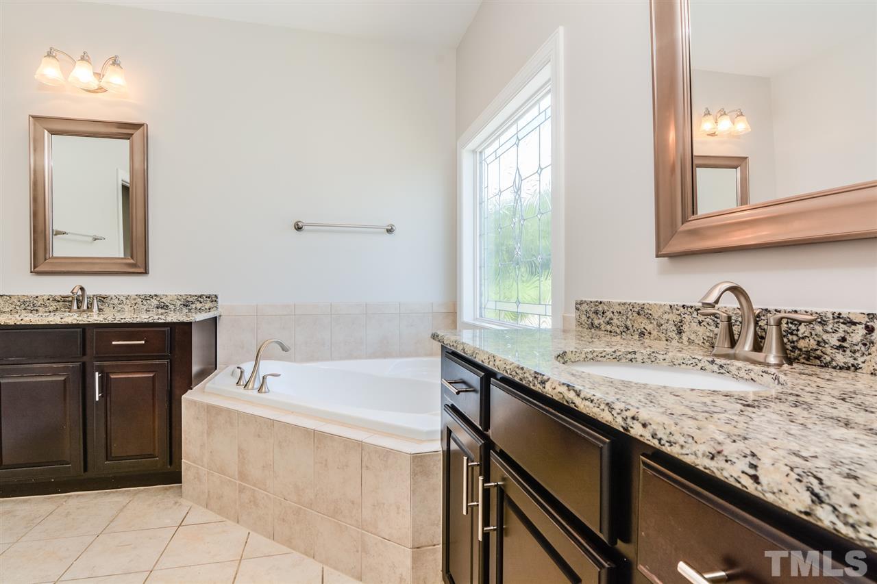 5646 Wade Park Boulevard Raleigh, NC 27607 - Photo 11 of 20 a bathroom with a granite countertop sink mirror and bathtub