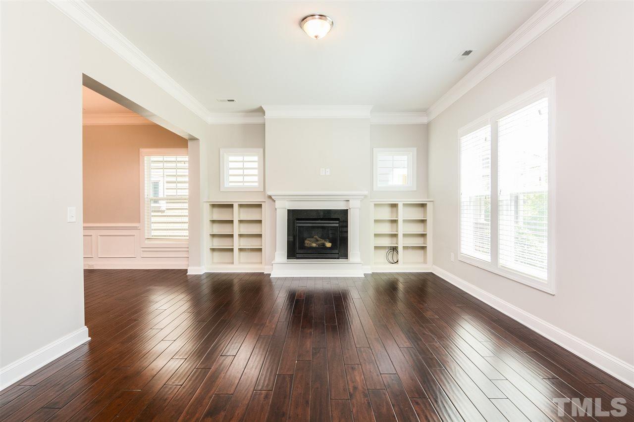 5646 Wade Park Boulevard Raleigh, NC 27607 - Photo 3 of 20 an empty room with wooden floor and fireplace