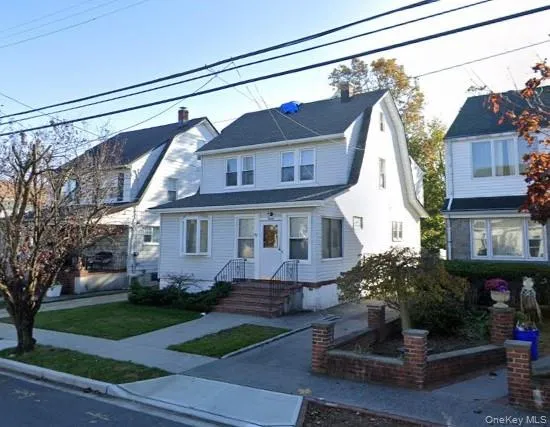 a view of a house with a small yard plants and large tree