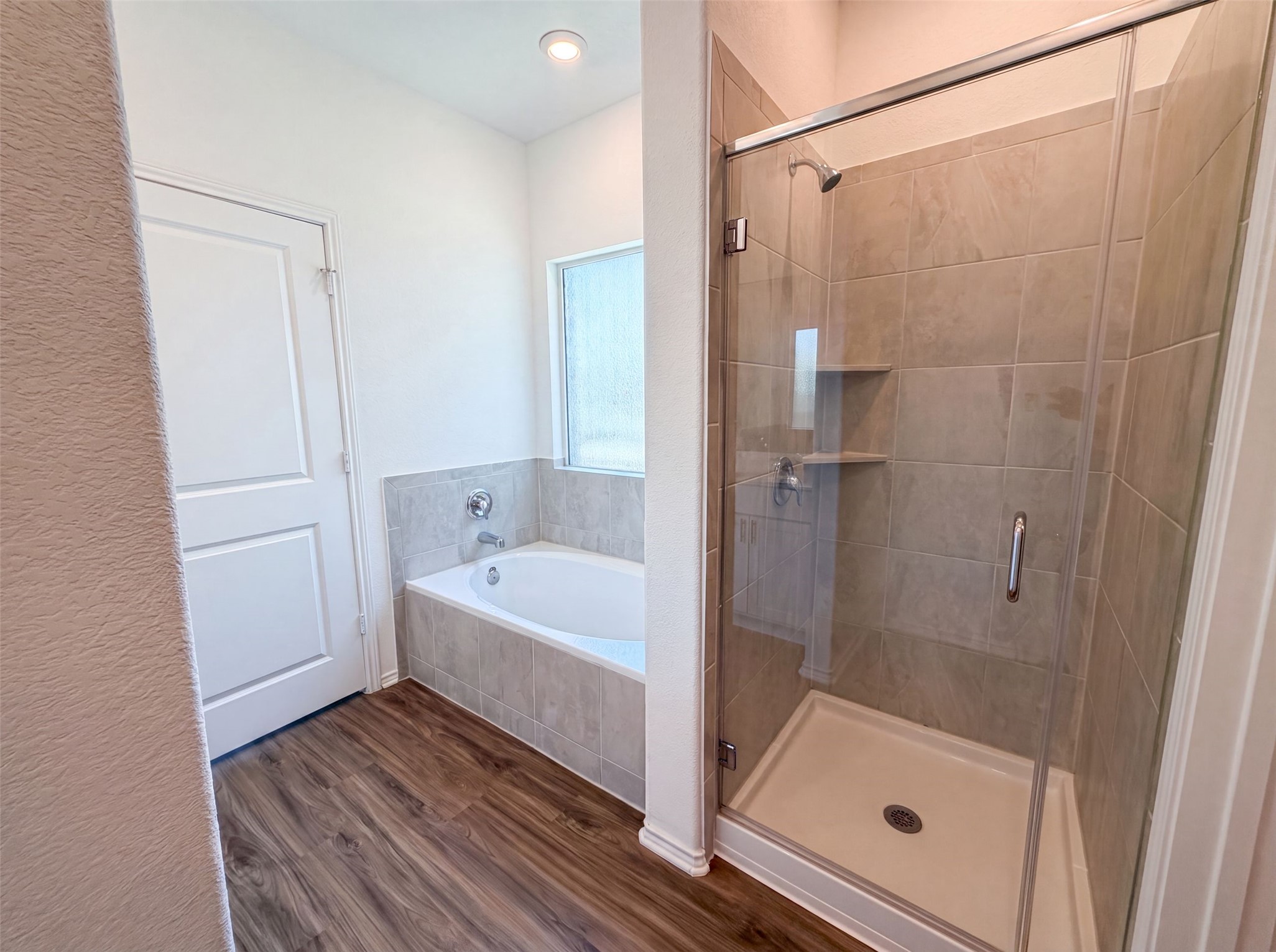 424 Wolf Springs Road Georgetown, TX 78628 - Photo 13 of 15 A well-appointed primary bathroom showcases a soaking tub and a spacious glass-enclosed shower.