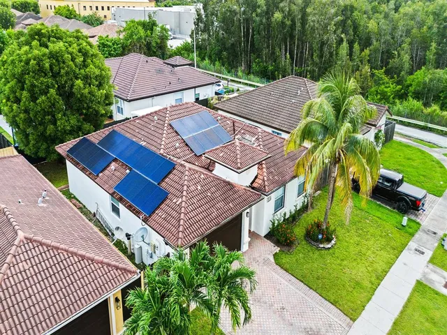 an aerial view of residential houses with outdoor space and a lake view