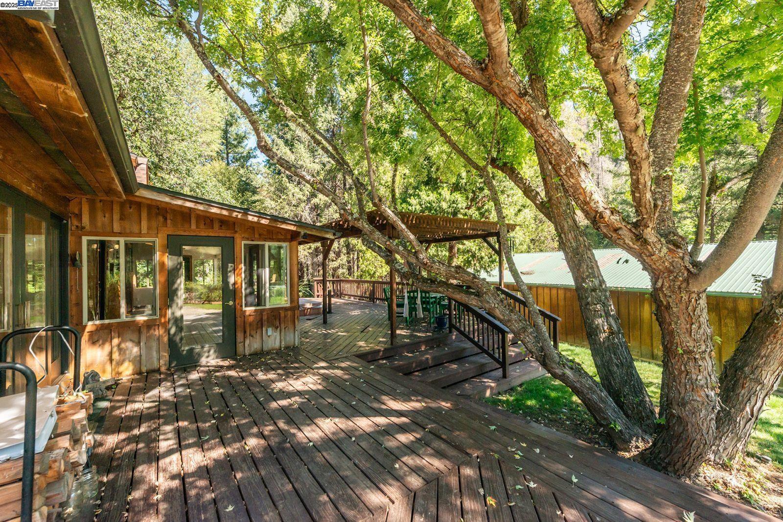 4481 Rush Creek Road Lewiston, CA 96052 - Photo 31 of 50 a backyard of a house with table and chairs under an umbrella