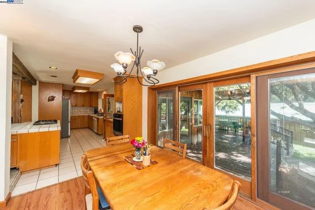 a view of a dining room with furniture a chandelier and wooden floor