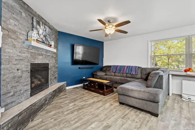 a living room with furniture a flat screen tv and a fireplace