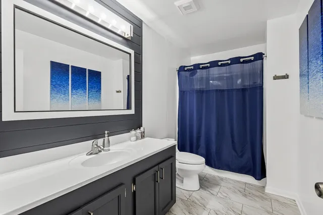 a bathroom with a double vanity sink and a toilet