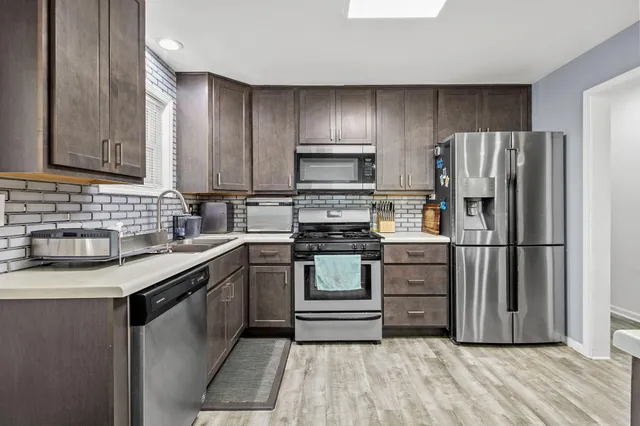 a kitchen with a refrigerator stove and sink