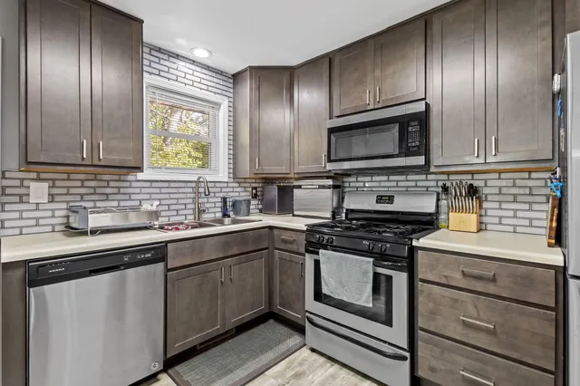 a kitchen with cabinets stainless steel appliances and sink