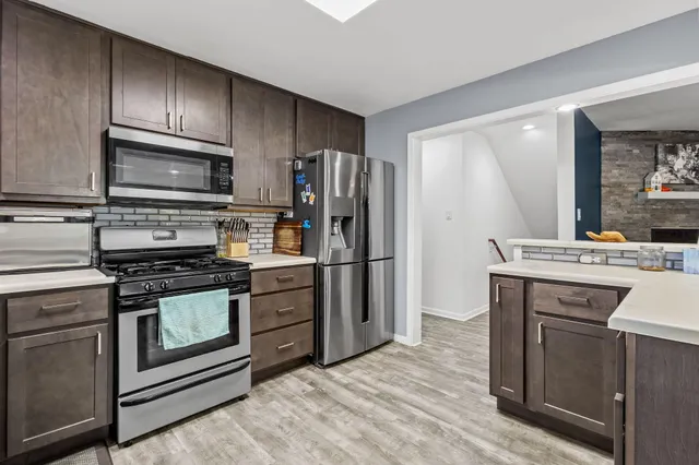 a kitchen with stainless steel appliances granite countertop a stove microwave and refrigerator