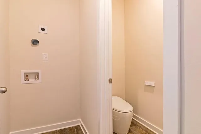 a white toilet sitting next to a shower