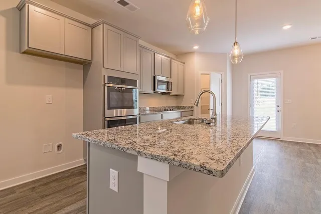 a kitchen with stainless steel appliances granite countertop a sink refrigerator and cabinets