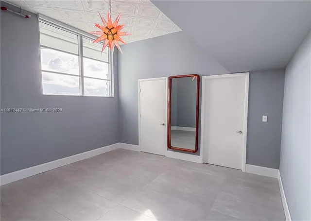 an empty room with closet and a window