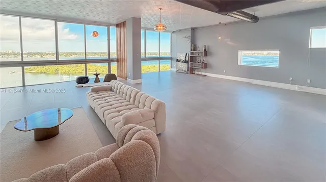 a living room with furniture and a floor to ceiling window