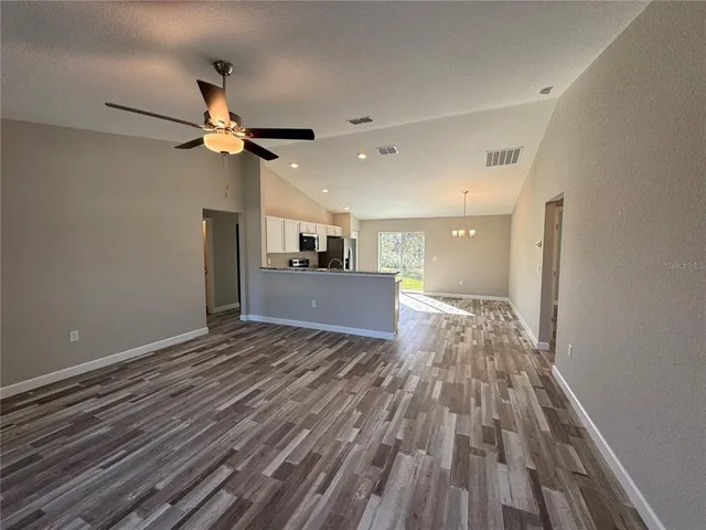 a view of a room with a ceiling fan and wooden floor