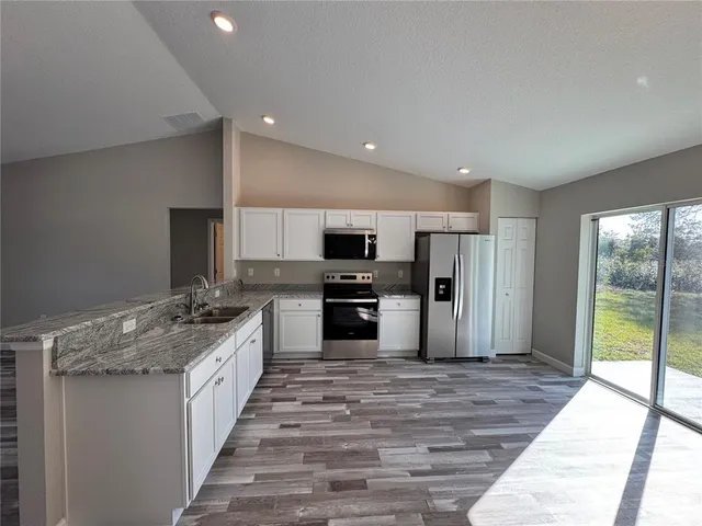 a large kitchen with kitchen island a sink stainless steel appliances and cabinets