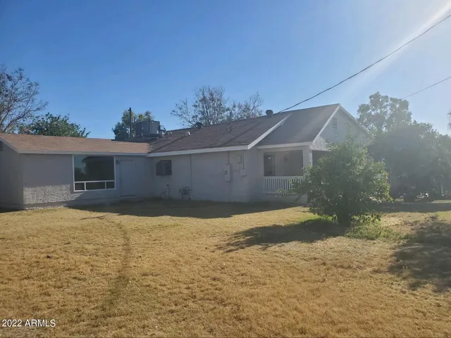 a front view of house with yard and trees in the background