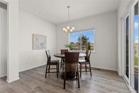 a dining room with furniture a chandelier and wooden floor