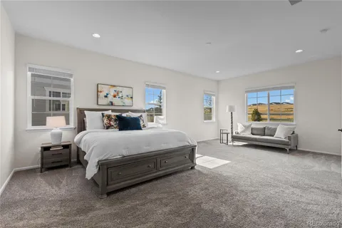 a spacious bedroom with a bed and a large window