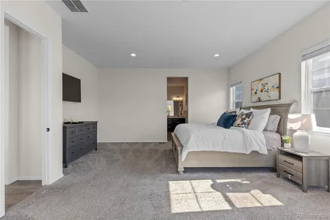 a spacious bedroom with a bed and a couch