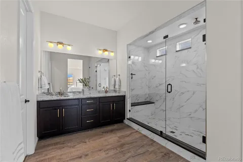 a bathroom with a granite countertop sink a mirror and shower