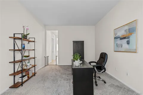 a view of a workspace with furniture and a window
