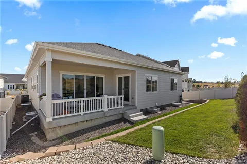 a view of a house with a small yard and wooden fence