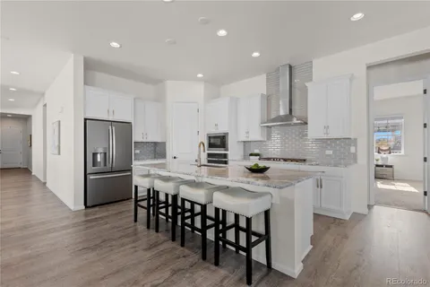 a kitchen with stainless steel appliances granite countertop a table chairs sink refrigerator and microwave