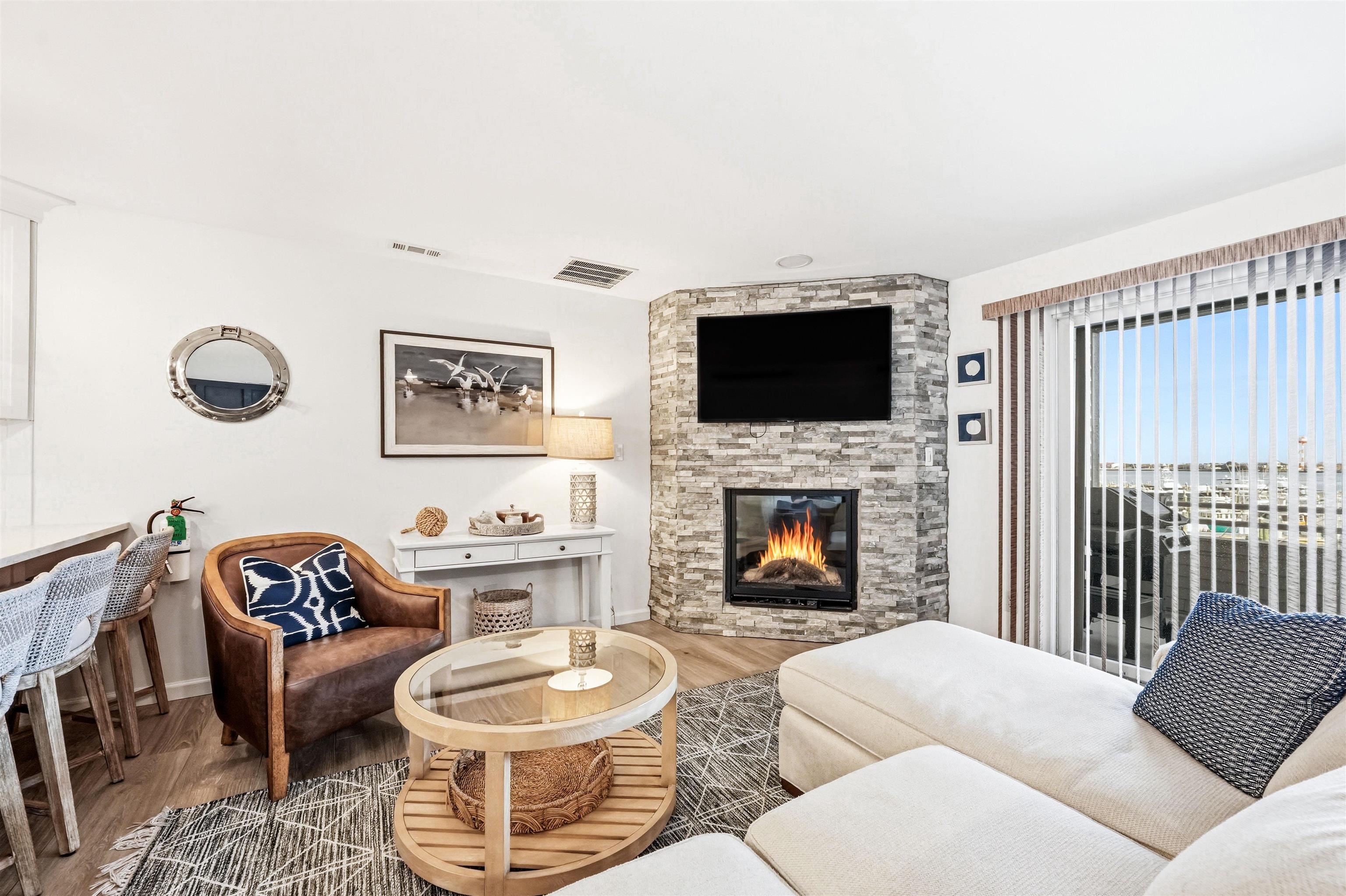 902 Ocean, Unit 906 Cape May, NJ 08204 - Photo 14 of 47 a living room with furniture a flat screen tv and a fireplace
