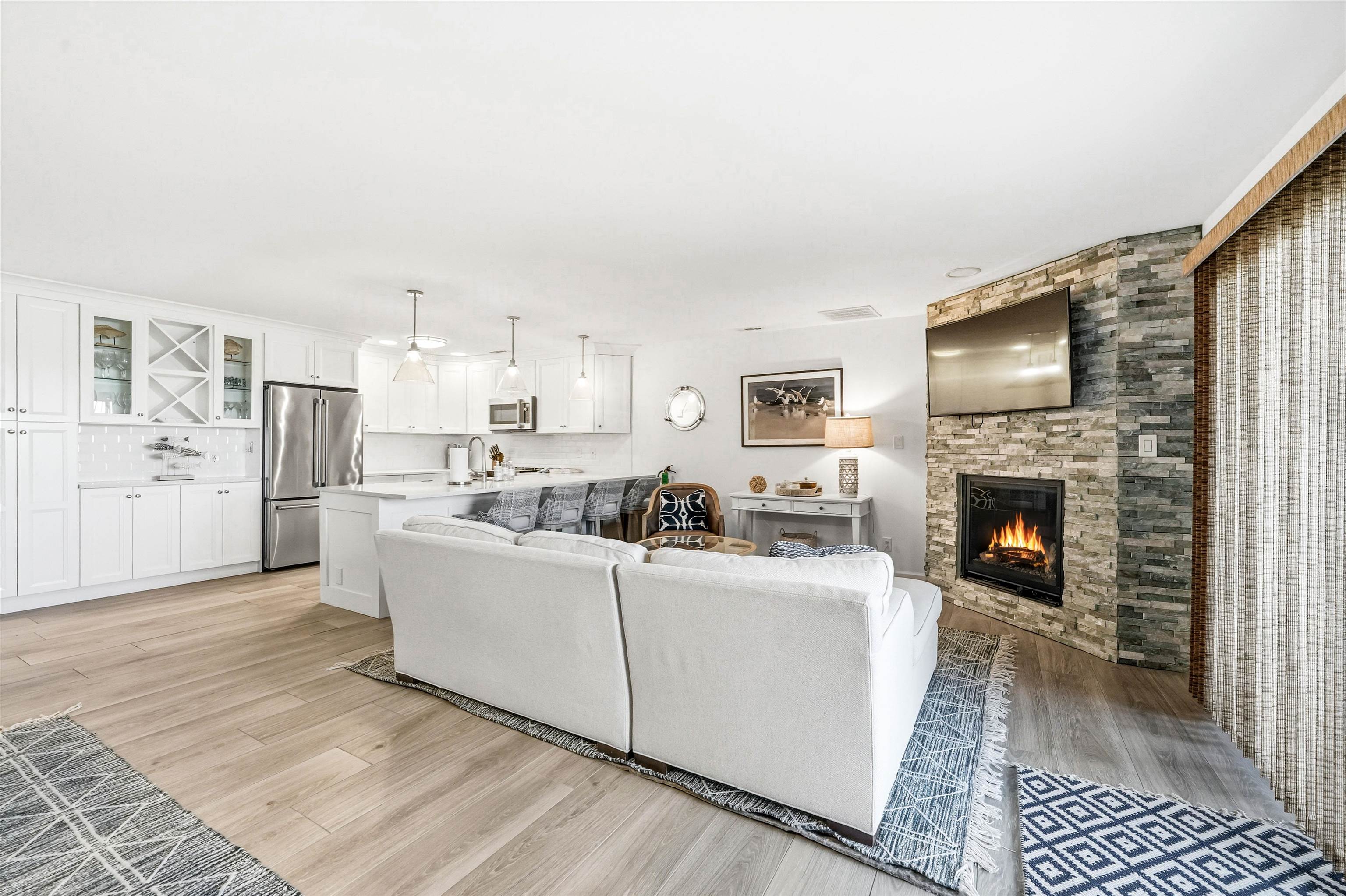 902 Ocean, Unit 906 Cape May, NJ 08204 - Photo 15 of 47 a living room with furniture a fireplace and kitchen view