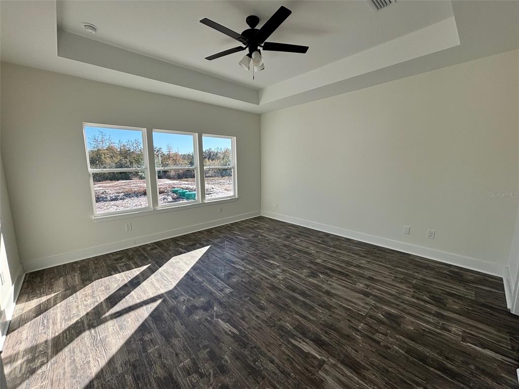 5949 South E County Road 21B Keystone Heights, FL 32656 - Photo 11 of 30 a view of a room with wooden floor a ceiling fan and windows